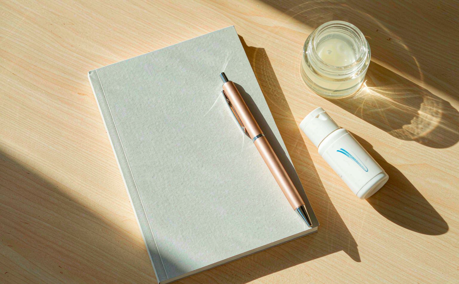 Notebook, pen and serum sample bottles on a desk during product development briefing